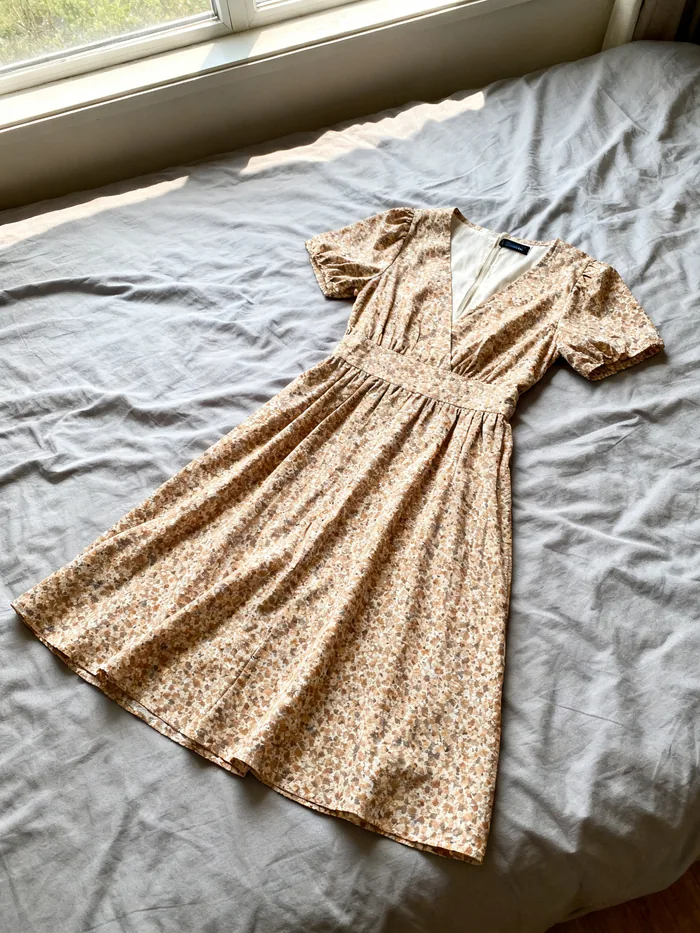 The dress as it arrived — creased, on a bed.