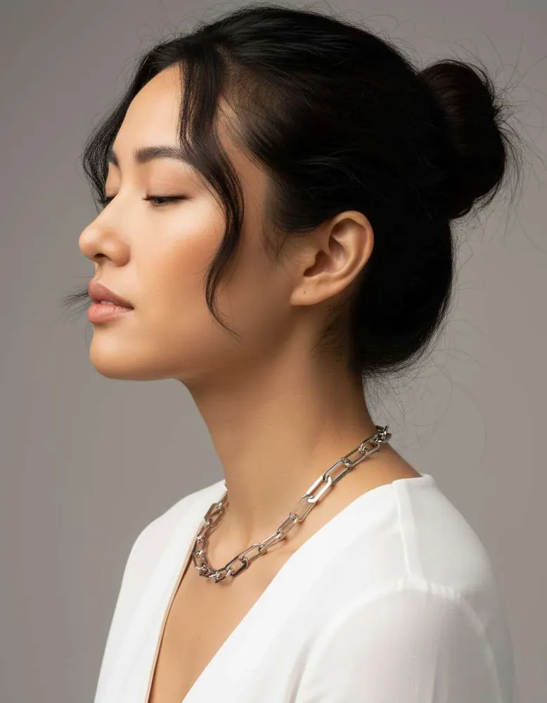 Chunky silver chain-link necklace shown on an AI fashion model after virtual try-on