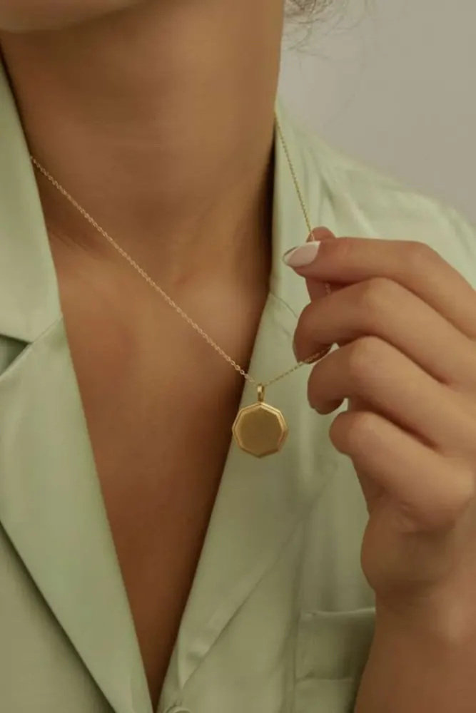 Gold locket necklace shown on an AI fashion model after virtual try-on